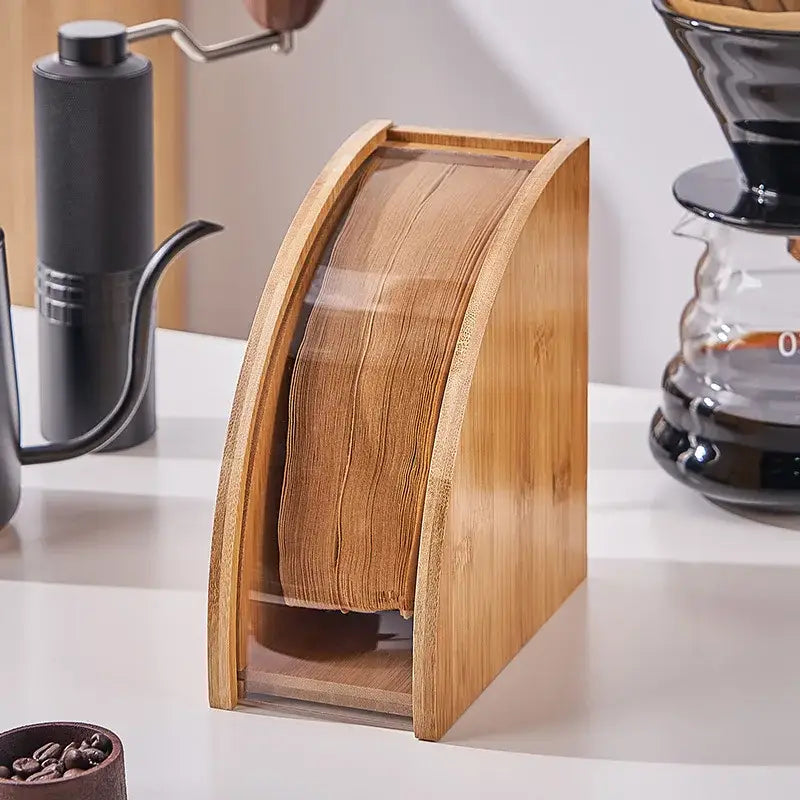A sleek light-brown natural bamboo coffee filter holder with curved design and transparent front panel for kitchen storage