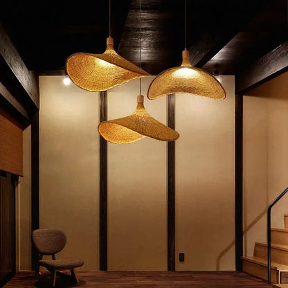Three golden-brown bamboo wicker chandelier pendant lights with natural woven design hanging in dining room