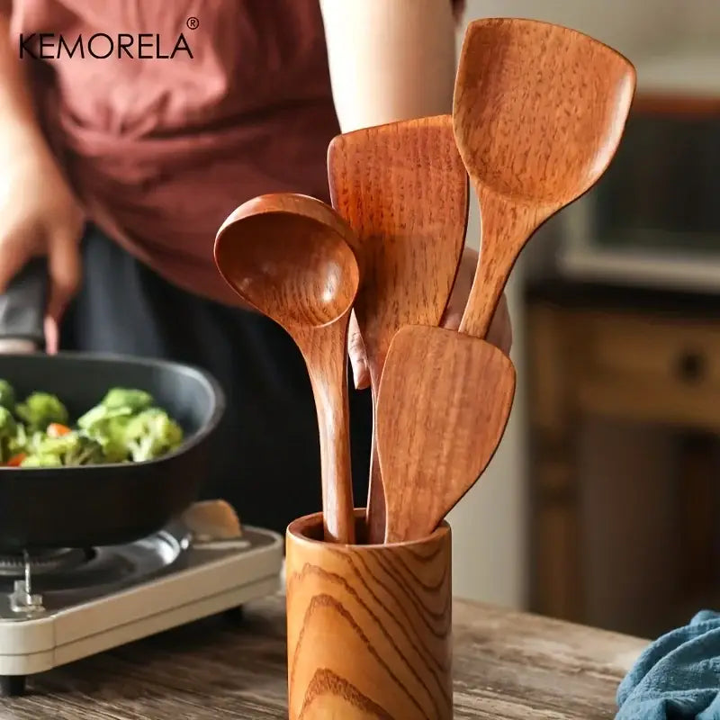 Set of five natural polished wooden kitchen utensils in warm brown tones with matching wooden kitchen utensil holder