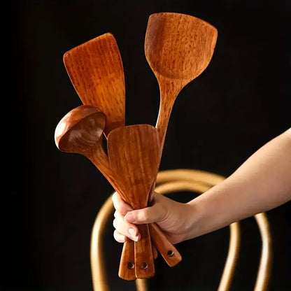 Set of four handcrafted wooden kitchen utensils with rich warm brown tones in a natural polished wooden kitchen utensil set