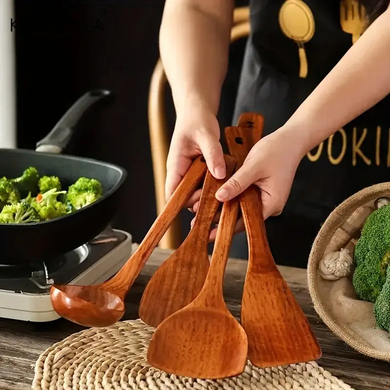Set of four natural polished wooden kitchen utensils including ladle and spatulas in a 4 piece kitchen utensil set