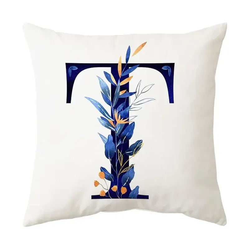 White throw pillow with navy blue stylized t and gold accents featuring blue alphabet flower for bedroom decorbites decor