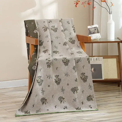 A light gray woven cotton gauze blanket with black floral pattern displayed with navy blue gold hibiscus cat bath towel decorbites cat bath