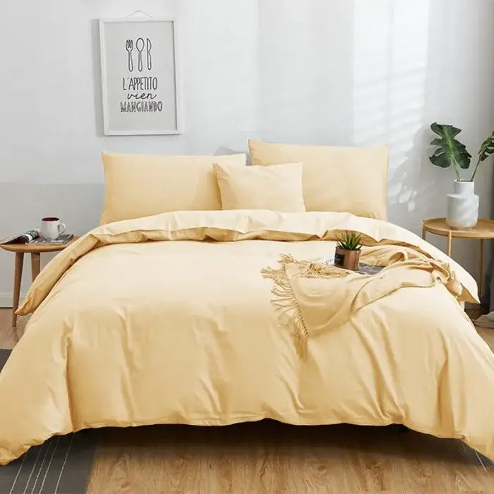 Cream-colored satin-like bedding set with matching pillows and fringed throw blanket in solid color decorbites cotton 4pcs set