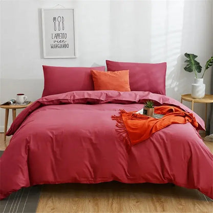 A plush deep red solid color decorbites cotton 4pcs bedding set with matching and orange accent pillows