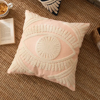 A soft pink pillow cover with a prominent cream embroidered cotton eye design for living room decorbites decor