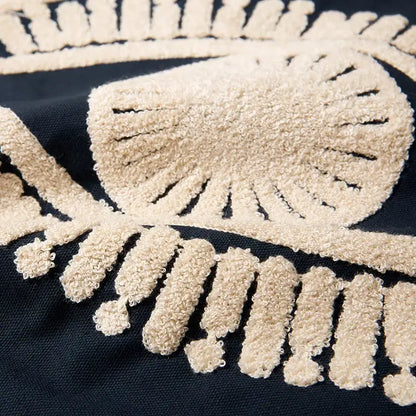 Beige textured skull and crossbones embroidered cotton patch on navy and cream pillow cover for living room decor