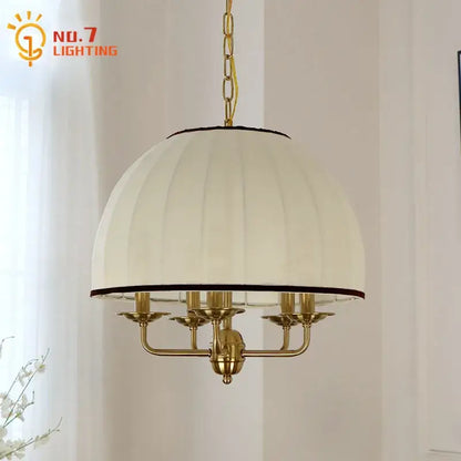 Cream neoclassical pendant light with cream pleated fabric shade black trim brass frame and five candle-style arms