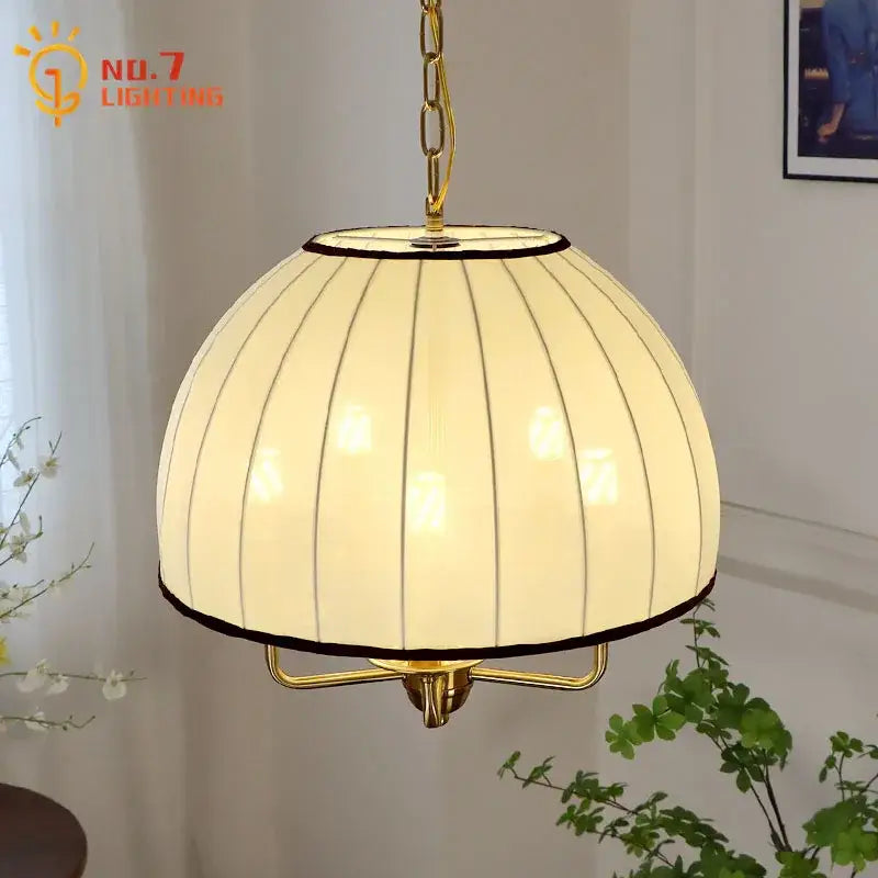 A warm cream neoclassical pendant light with vertical ribbed glass and brass frame for dining room decorbites