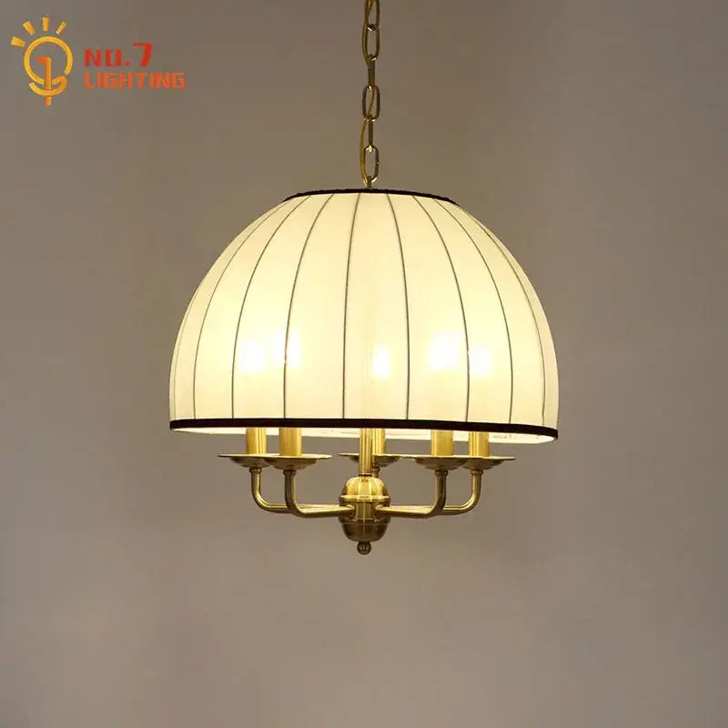 Warm-toned cream neoclassical pendant light with vertical striped glass panels and brass frame for dining room decorbites