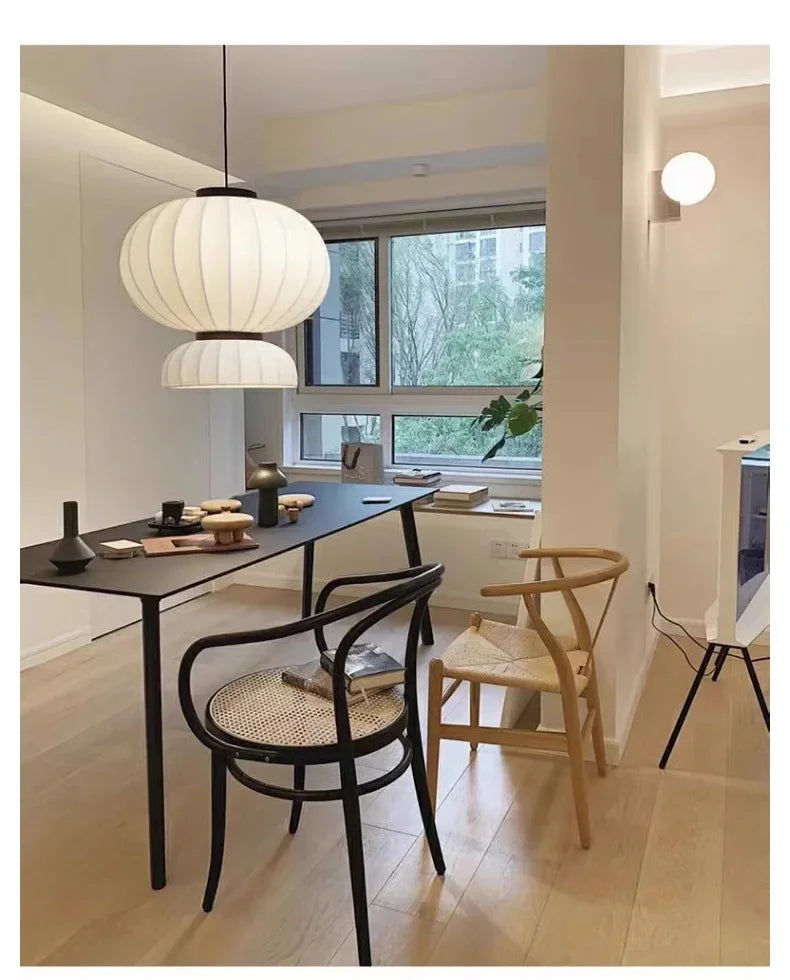 White pleated paper pendant lamp with black metal accents hanging above a dining table shop hanging light dining room lantern light