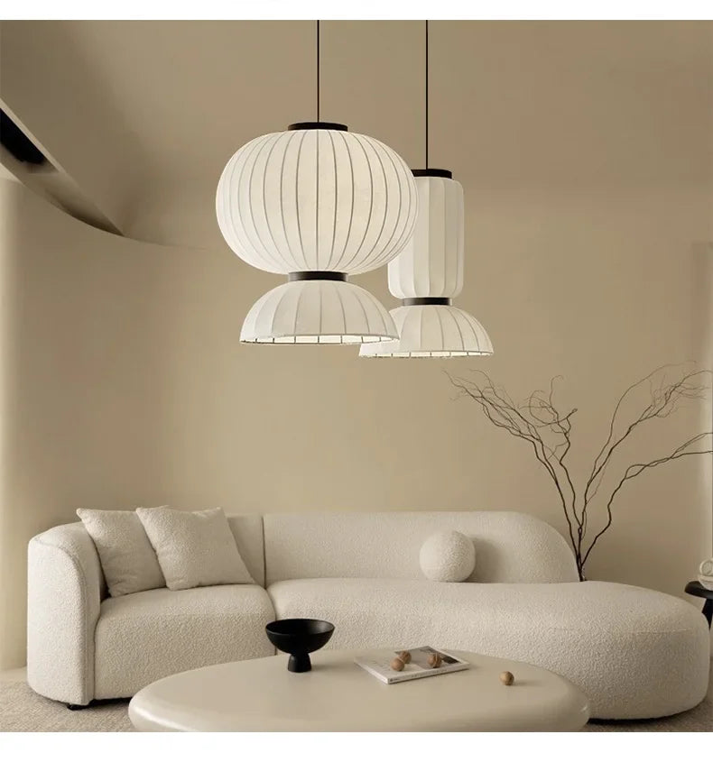 White pleated paper noguchi pendant lights with black metal accents hang above a dining room as shop hanging lantern light
