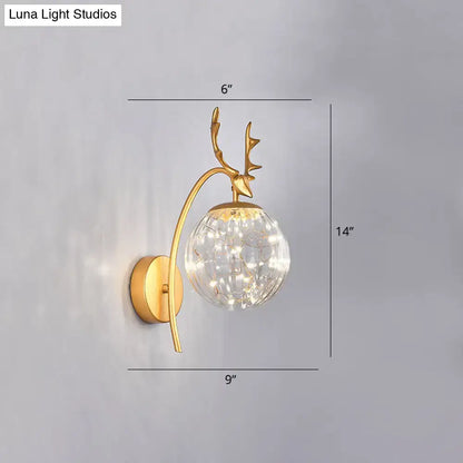 Gold-toned nordic ball wall mount deer-head sconce with clear crackled glass globe and warm led lights for bedroom use