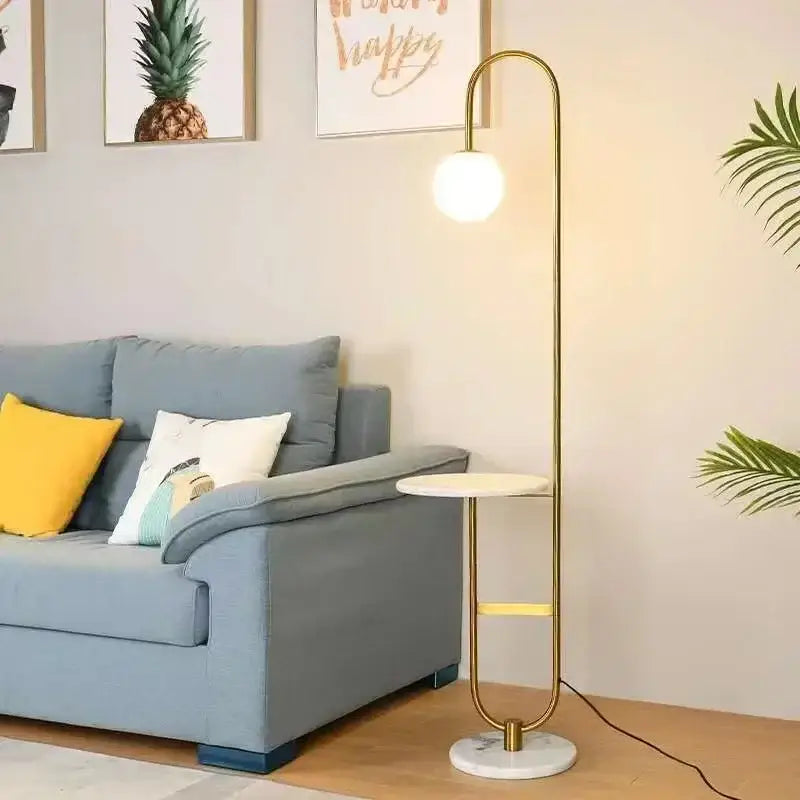 Gold-toned minimalist floor lamp with curved design and white glass shade paired with black metal led floor lamp table