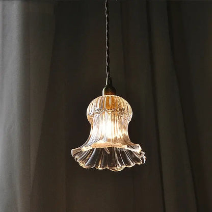 Nordic brass and ribbed glass pendant light fixture with clear glass and warm glow hanging from dark twisted cord