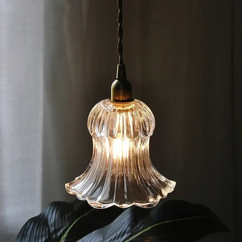Clear ribbed glass pendant light fixture with brass finish and twisted black cord for Nordic kitchen lighting