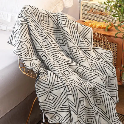 A cozy cream and black decorbites grey knitted woolen blanket with bold geometric patterns for living room decor