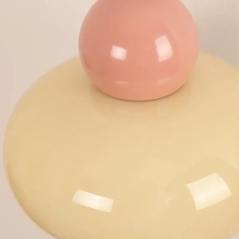 Nordic cream and blush pink glass wall light fixture with a smooth glossy sphere on a pale yellow base by decorbites iron nordic
