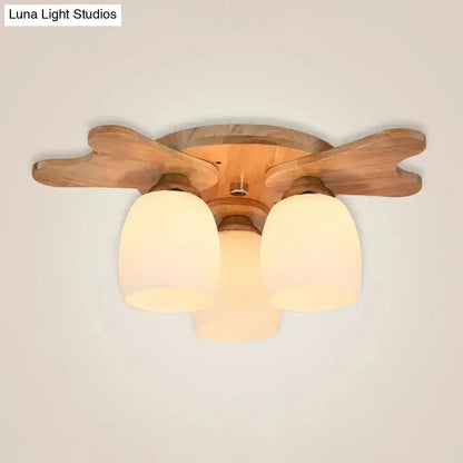 Nordic cream glass bell ceiling light with wooden antler arms and three warm-toned cream glass shades for bedroom
