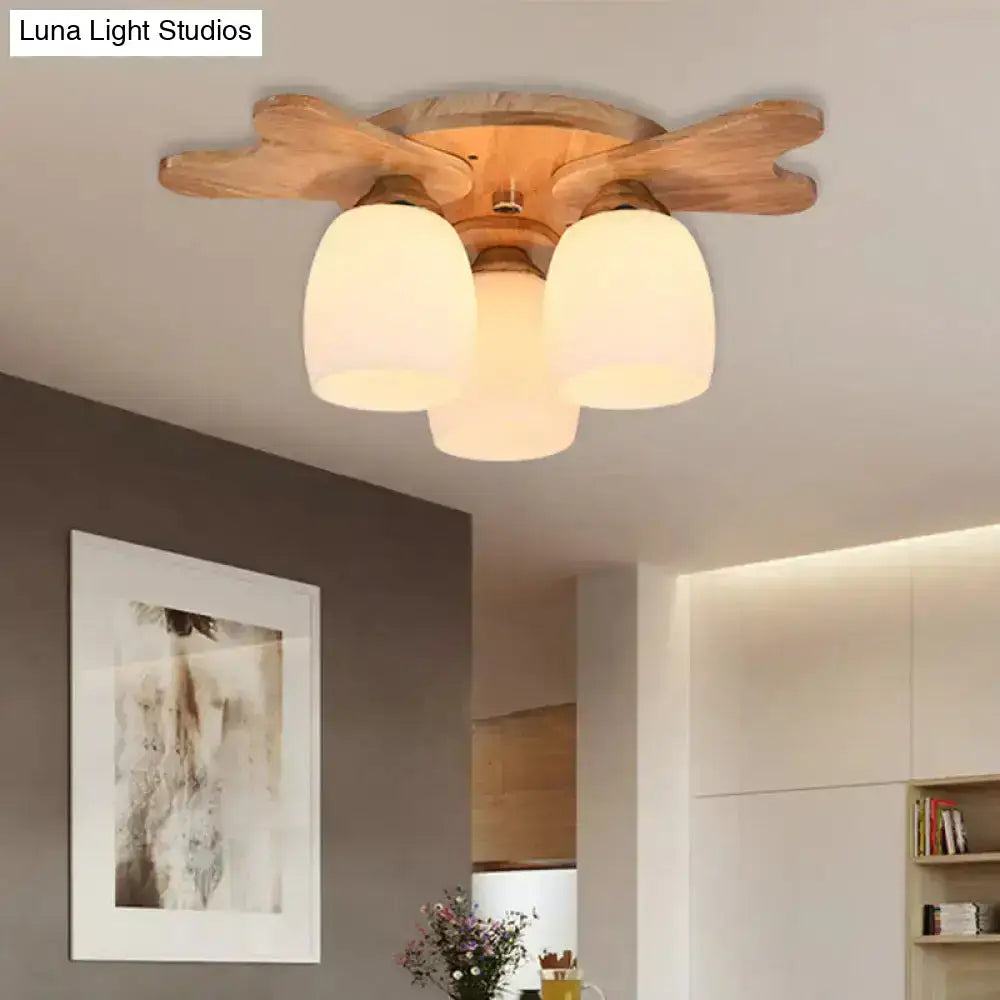 Wooden ceiling light with three cream glass bell frosted shades and natural finish for bedroom lighting
