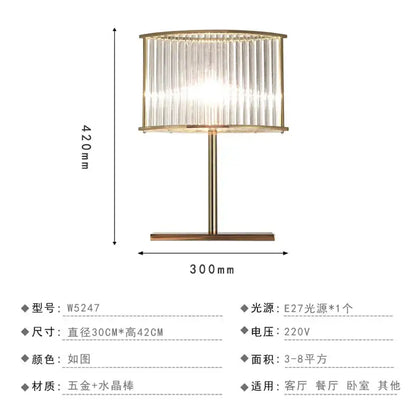 Gold-toned nordic crystal table lamp with cylindrical shade of vertical crystal rods and brass accents for bedroom