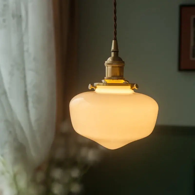 Nordic frosted glass led pendant lamp with a warm brass-finished fixture and twisted cord ideal for bedroom lighting