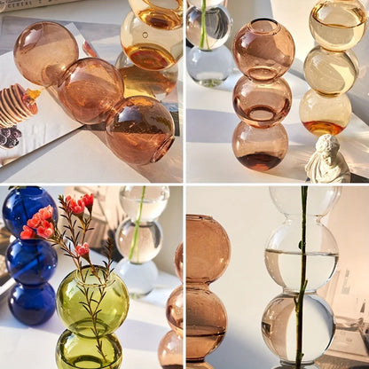 Stacked nordic glass bubble vases in amber green and blue hues with spherical segments for hydroponic planter decor