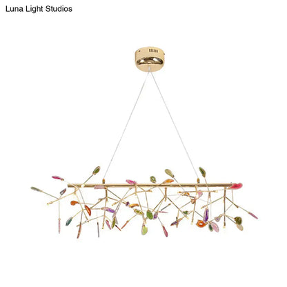 A modern gold-toned pendant ceiling light with colorful glass leaves for dining room light type and decor