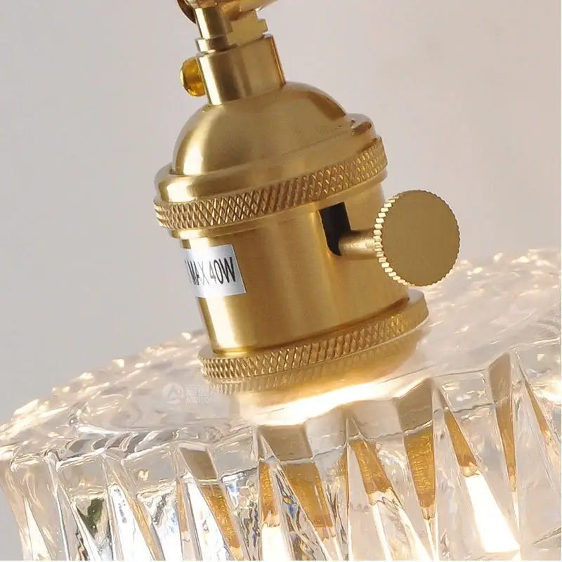 Nordic gold brass led wall sconce with adjustable arm featuring a textured brass led wall socket on faceted crystal shade