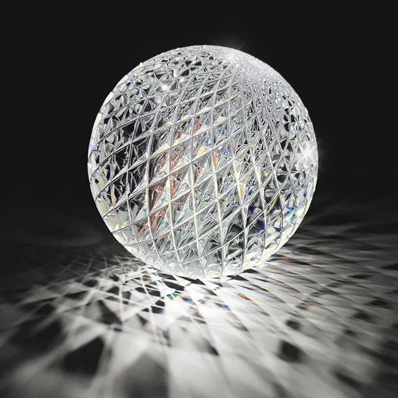 A clear crystal sphere pendant lamp with geometric lattice pattern refracting rainbow light for nordic dining room decor