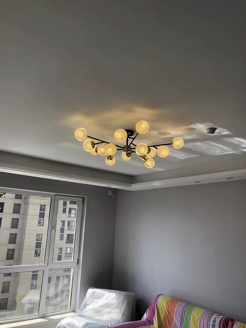 Modern chandelier with warm-toned textured glass globe bulbs on black metal frame for nordic dining room lighting