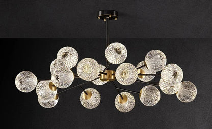 Modern chandelier with clear textured glass spheres and gold-toned metal arms for nordic dining room lighting