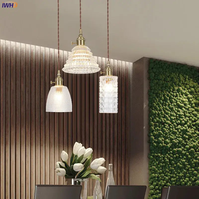 Three elegant nordic japan style pendant lights with textured clear glass shades and brass fixtures for dining room lighting