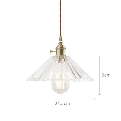 A nordic japan style glass pendant light with clear faceted glass, brass fixture, and twisted brown cord for dining room