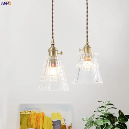 Two nordic japan style pendant lights with brass fixtures and textured clear glass shades for dining room use