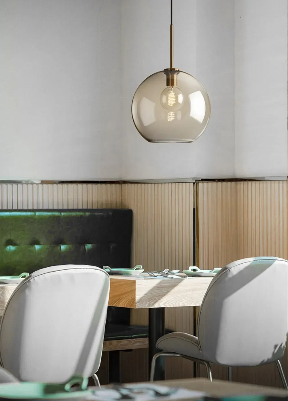 A nordic led glass pendant light with a smoked glass globe and brass accents above the dining room table