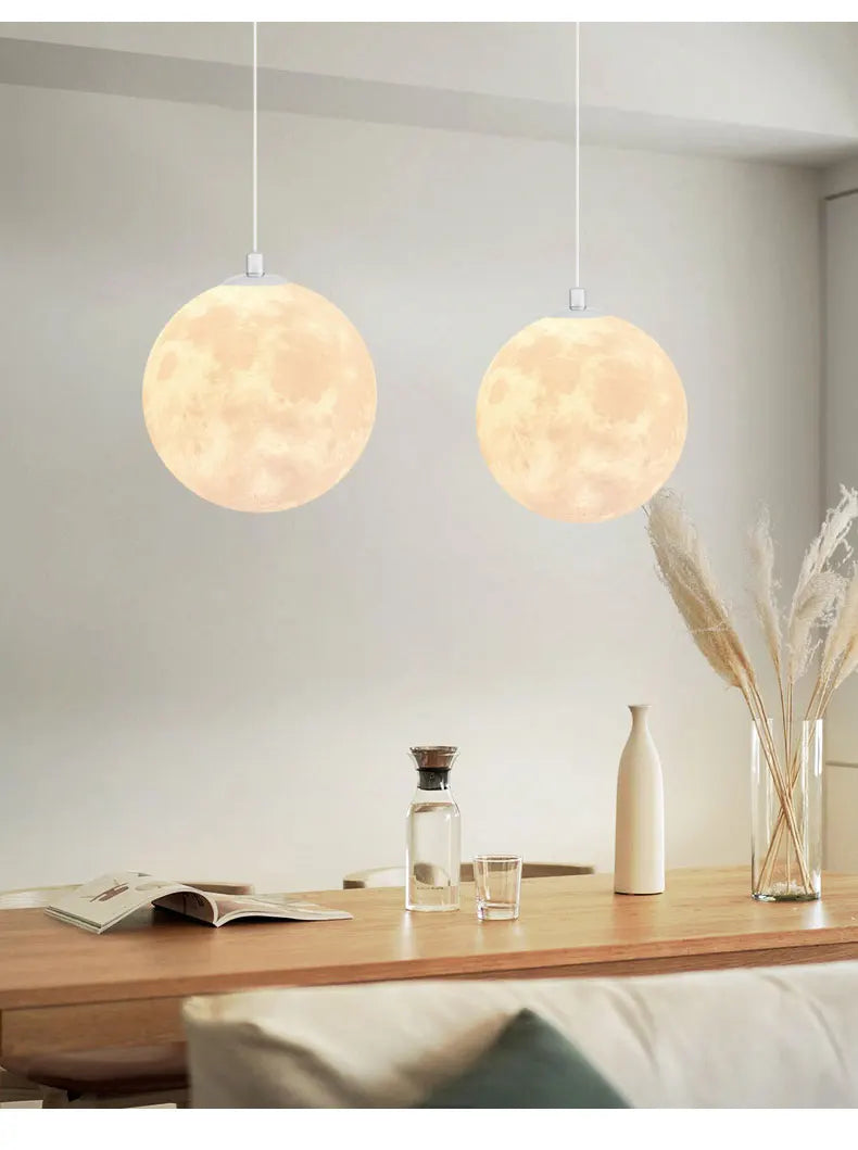 Two warm-toned nordic led moon pendant chandeliers with spherical realistic moon texture for dining room kitchen lighting
