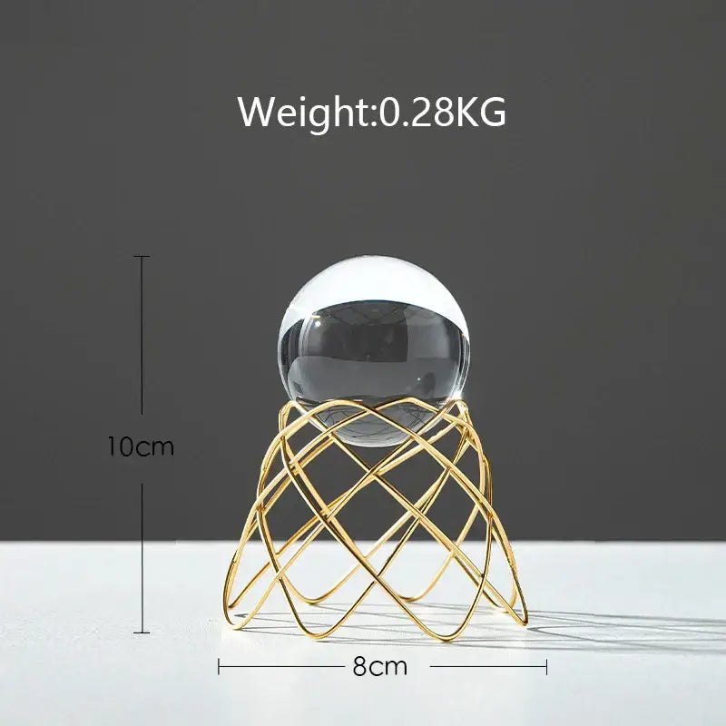 A nordic light luxury crystal ball craft with a sleek black and white glass sphere on a gold-toned wireframe stand