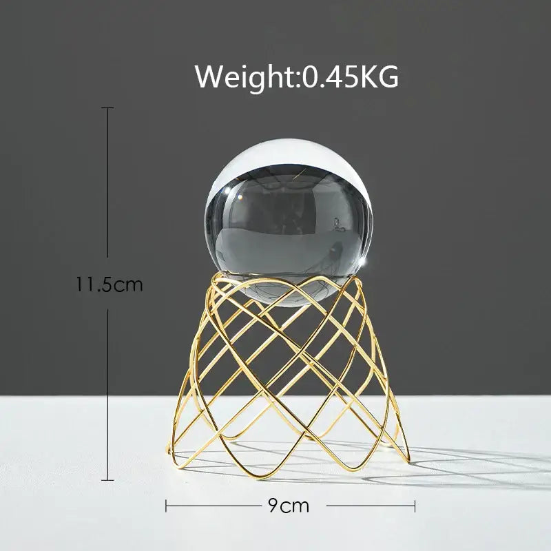 A nordic light luxury two-toned crystal ball with black and white glass on a gold wireframe stand for living room decor