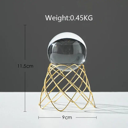 A nordic light luxury two-toned crystal ball with black and white glass on a gold wireframe stand for living room decor