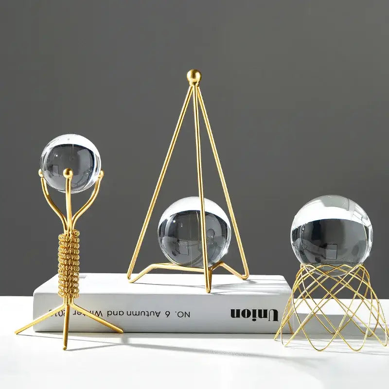 Three gold-toned metal stands with clear reflective crystal balls for nordic light luxury crystal ball crafts decor