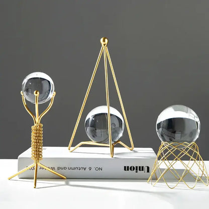 Three gold-toned metal stands with clear reflective crystal balls for nordic light luxury crystal ball crafts decor