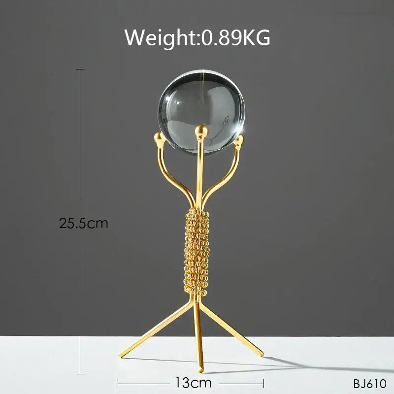 Gold-toned metal stand with a clear crystal ball for nordic light luxury crystal ball crafts living room decor