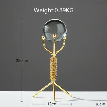 Gold-toned metal stand with a clear crystal ball for nordic light luxury crystal ball crafts living room decor