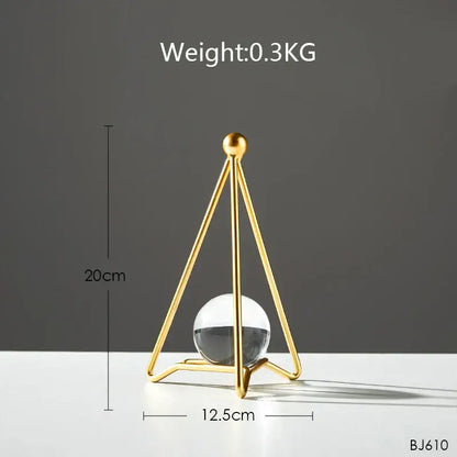 Gold-toned triangular metal stand holding a clear glass sphere with dark liquid for nordic light luxury crystal ball crafts