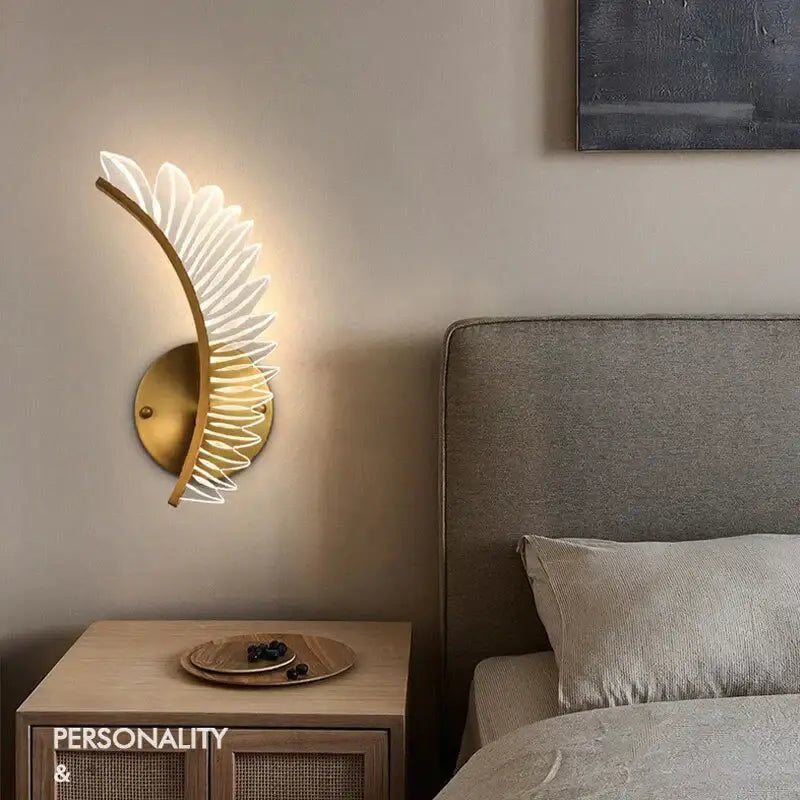 Gold-toned feather wall lamp with illuminated translucent white leaf segments nordic modern art bedside sconce