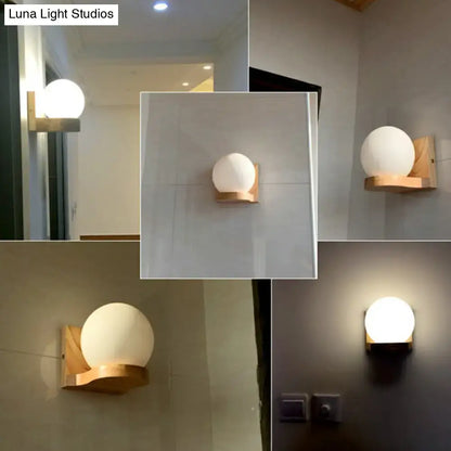 Minimalist wall light wall sconce with frosted white opal glass globe and natural wood base for bedroom use