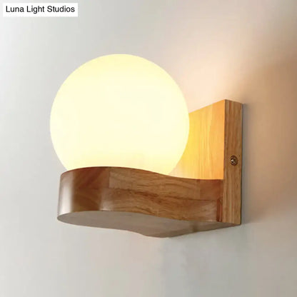 Nordic opal glass wall sconce with warm-toned spherical globe on natural wood base minimalist wall light for bedroom