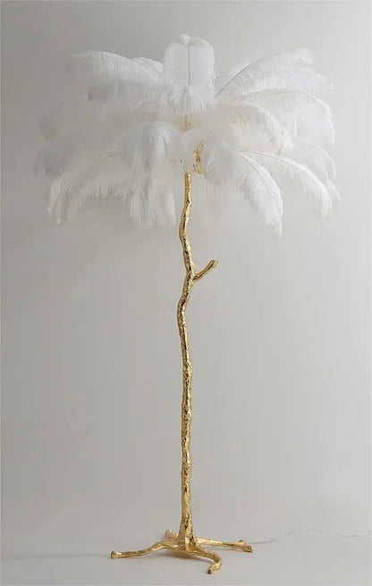 A tall elegant feather floor lamp with a golden branch-like base and white ostrich feathers for living room decor