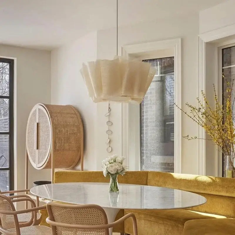 Nordic pendant light made of creamy white pleated fabric hanging above a marble dining room table
